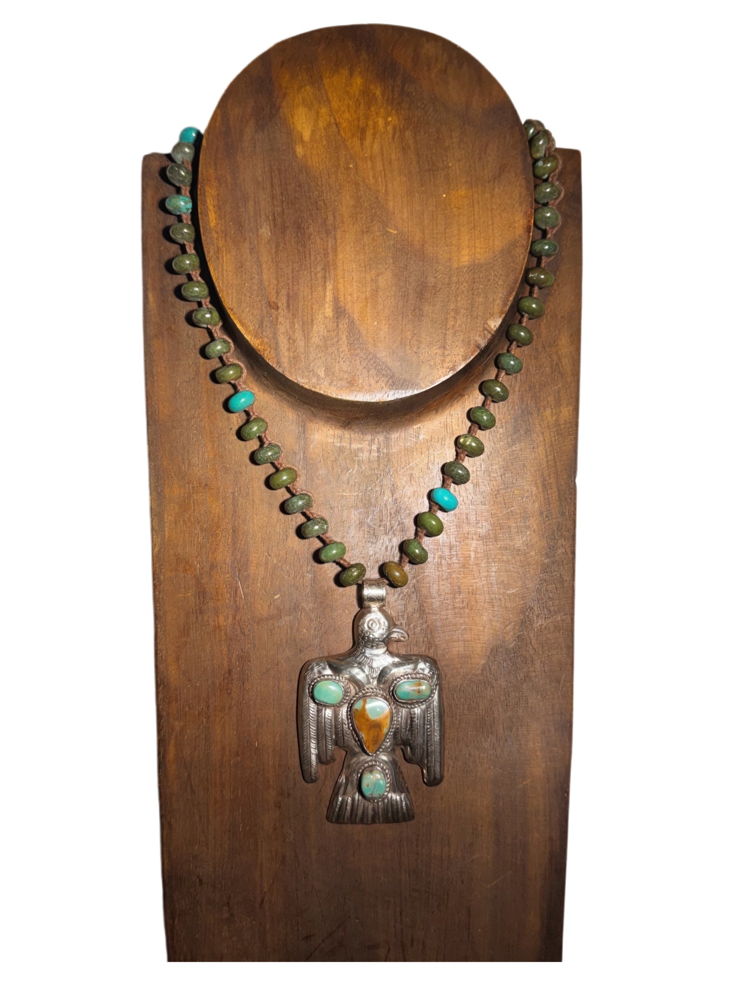 Necklace with a bird-shaped pendant on a wooden stand
