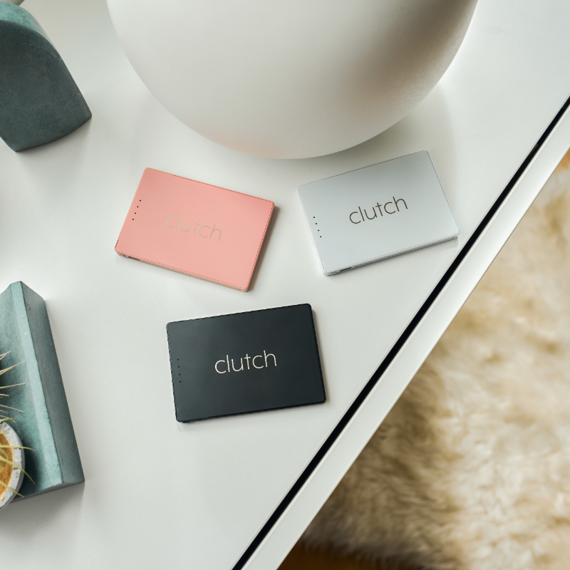 three portable chargers in black, white and pink