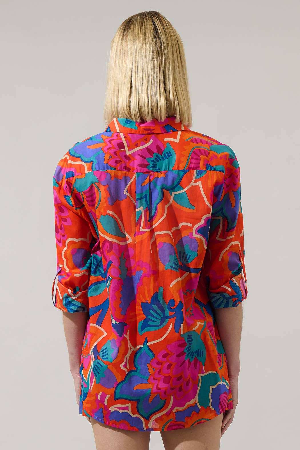 model in multi color tropical shorts with a matching button down blouse