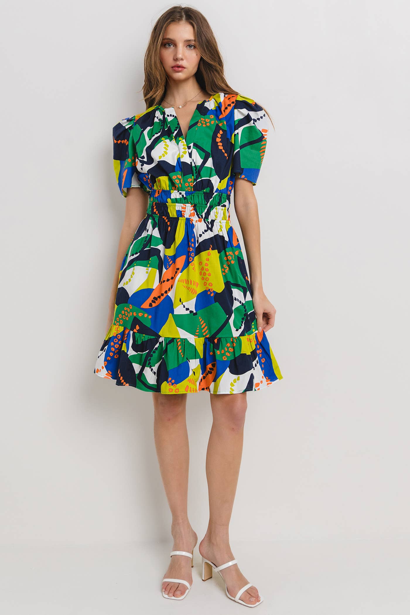 model is wearing a tropical printed dress with puffy sleeves