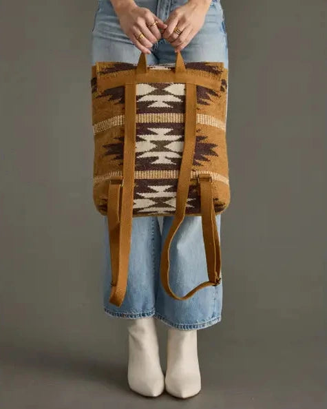 Person holding a patterned bag with a neutral background
