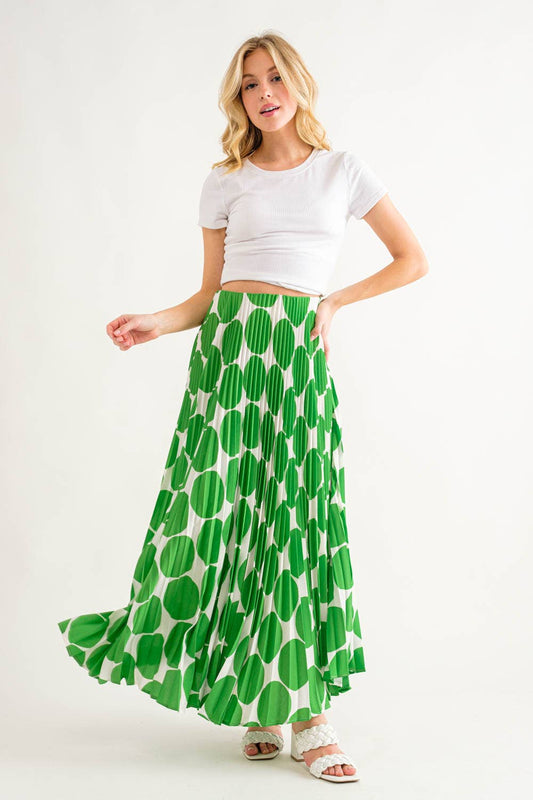 model is wearing a white top & kelly green polka dot skirt
