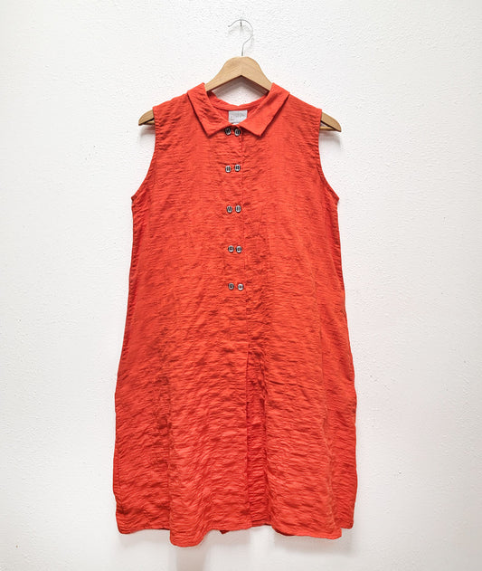 coral color sleeveless shirtdress with a textred body and black and white twin set buttons down the placket 
