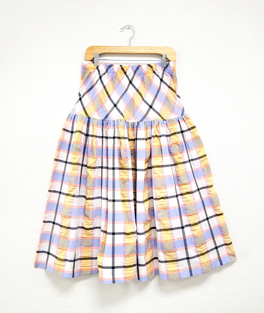 full gathered skirt with elastic waist and bias cut yoke in a plaid pastel pattern on hanger with white background