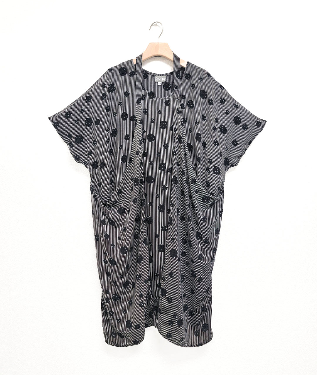 black and white stripe tunic with a black dot print circle design. dress has a strap from the hips worn around the neck