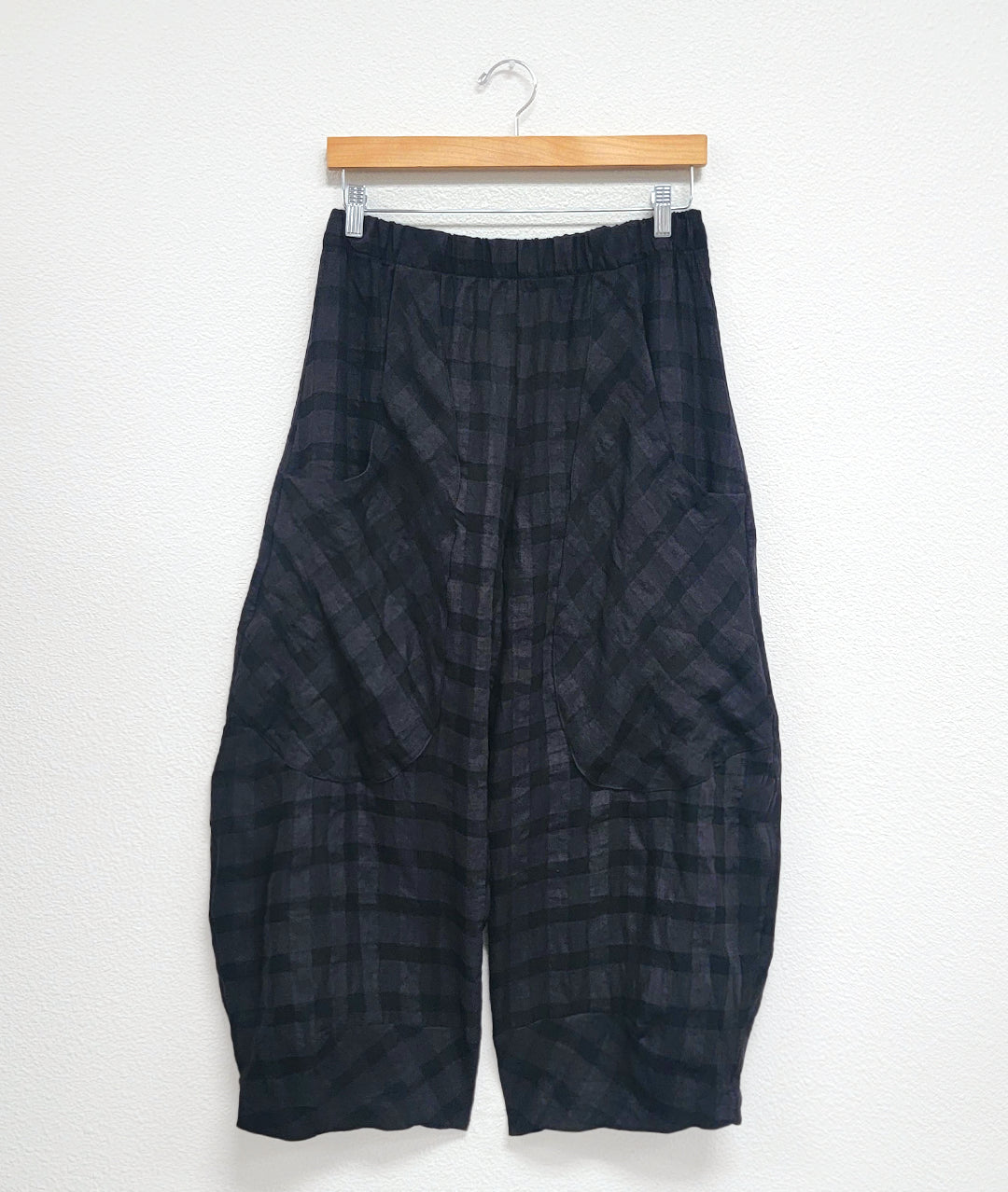 black, large plaid print wide leg pant with a tapered ankle, oversized exterior pockets, and an elastic waistband