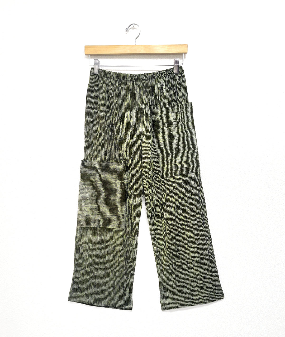 wide leg black and green striped pant with asymmetrical cargo pockets and an elastic waistband