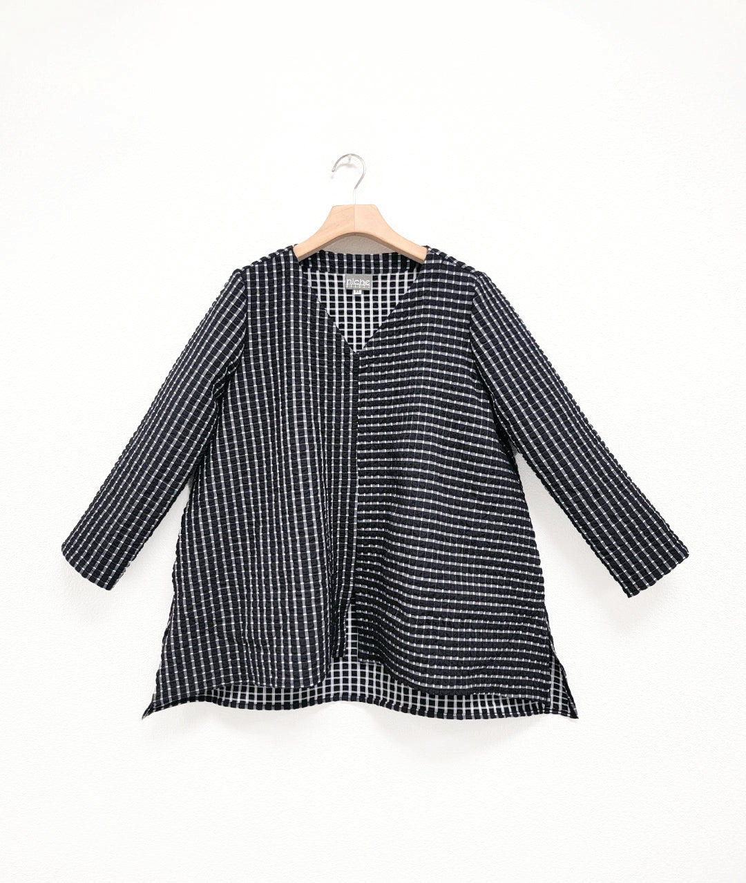black and white check print pullover top with contrasting panels and a v-neck