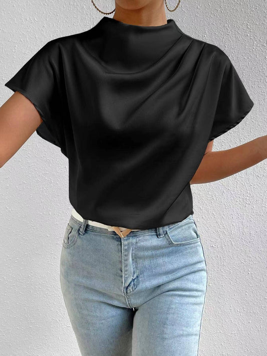 close-up of a model wearing light denim jeans and a satin mock neck black top