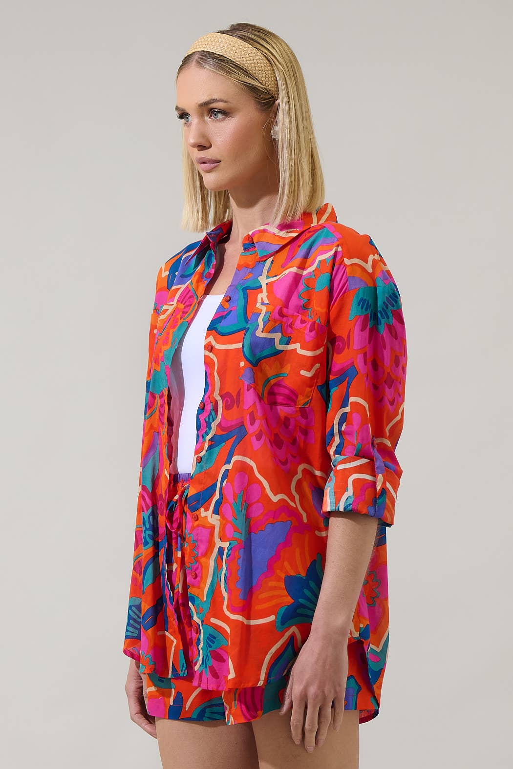 model in multi color tropical shorts with a matching button down blouse