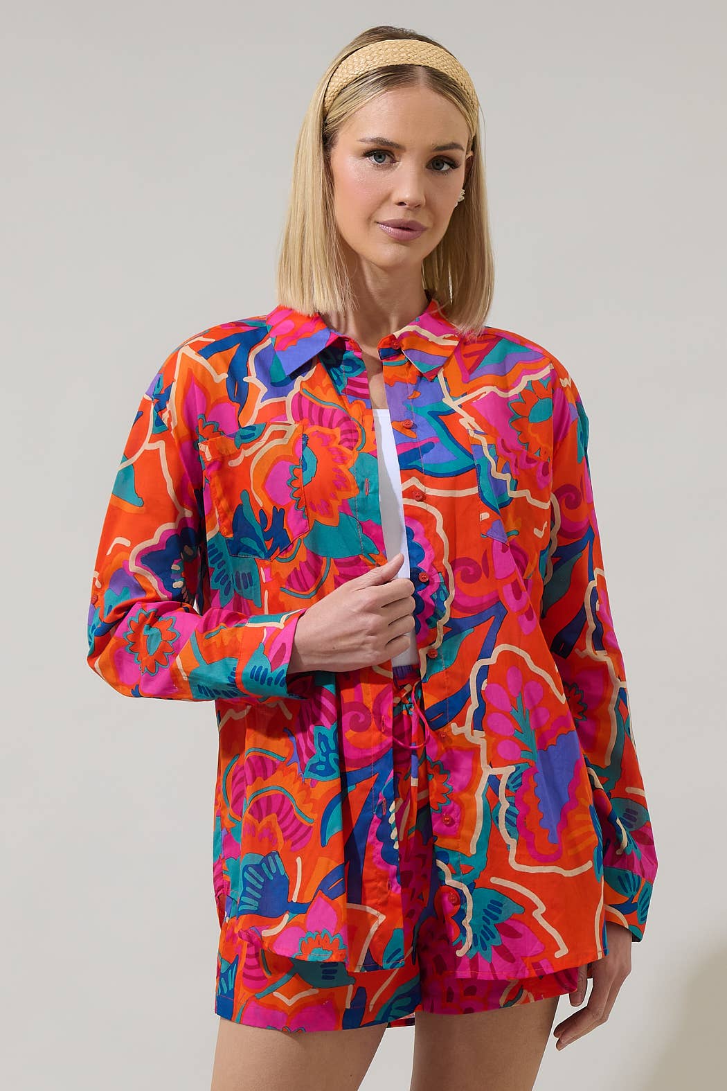 model in multi color tropical shorts with a matching button down blouse