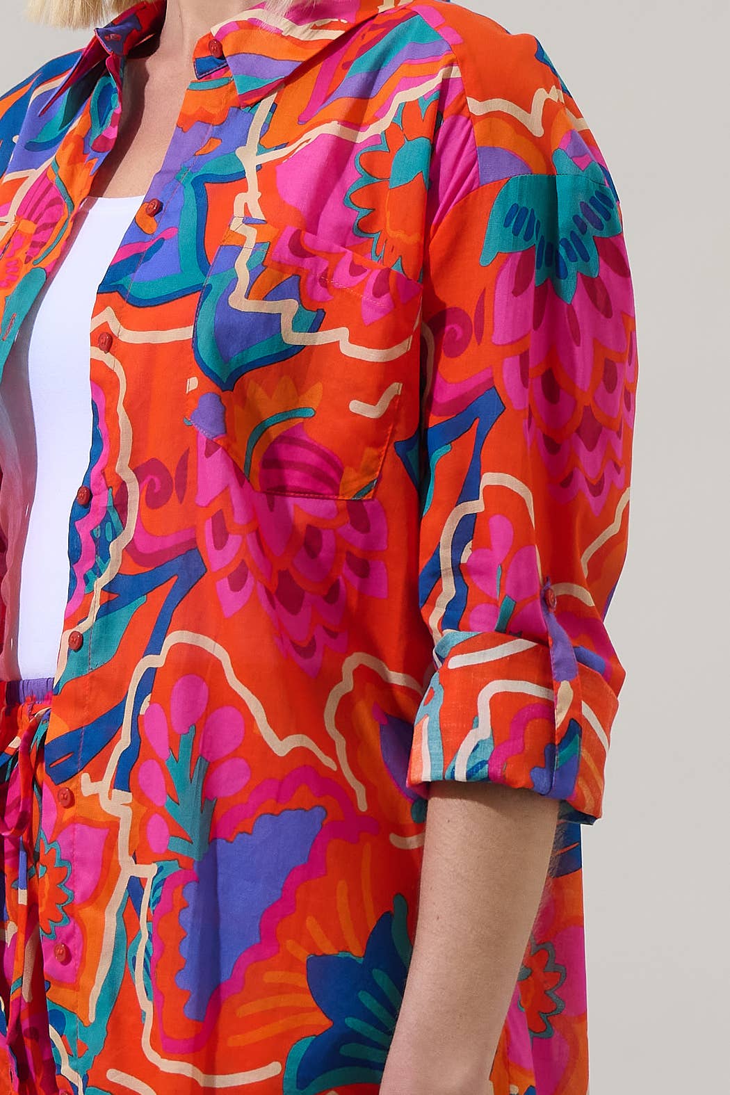 model in multi color tropical shorts with a matching button down blouse