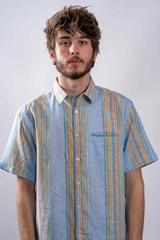 model wearing blue and colorful striped linen button up collared short sleeve shirt