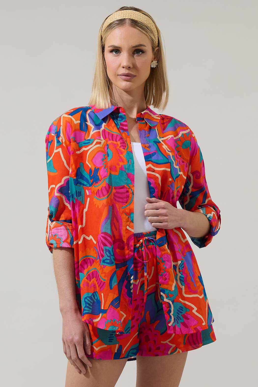 model in multi color tropical shorts with a matching button down blouse