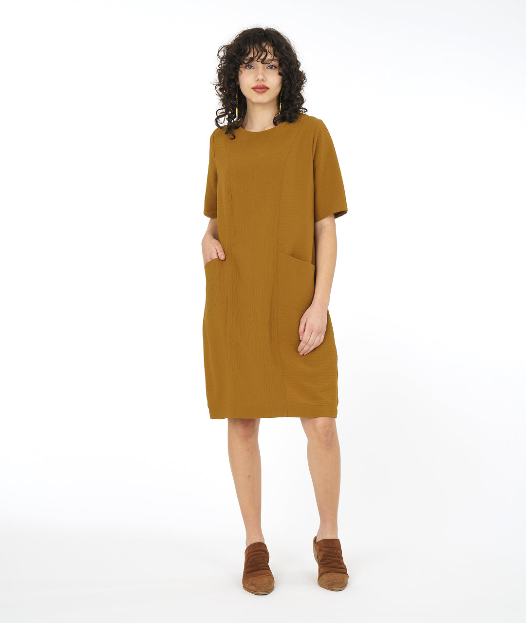model in a dijon yellow shift dress with princess seams and angled hip pockets