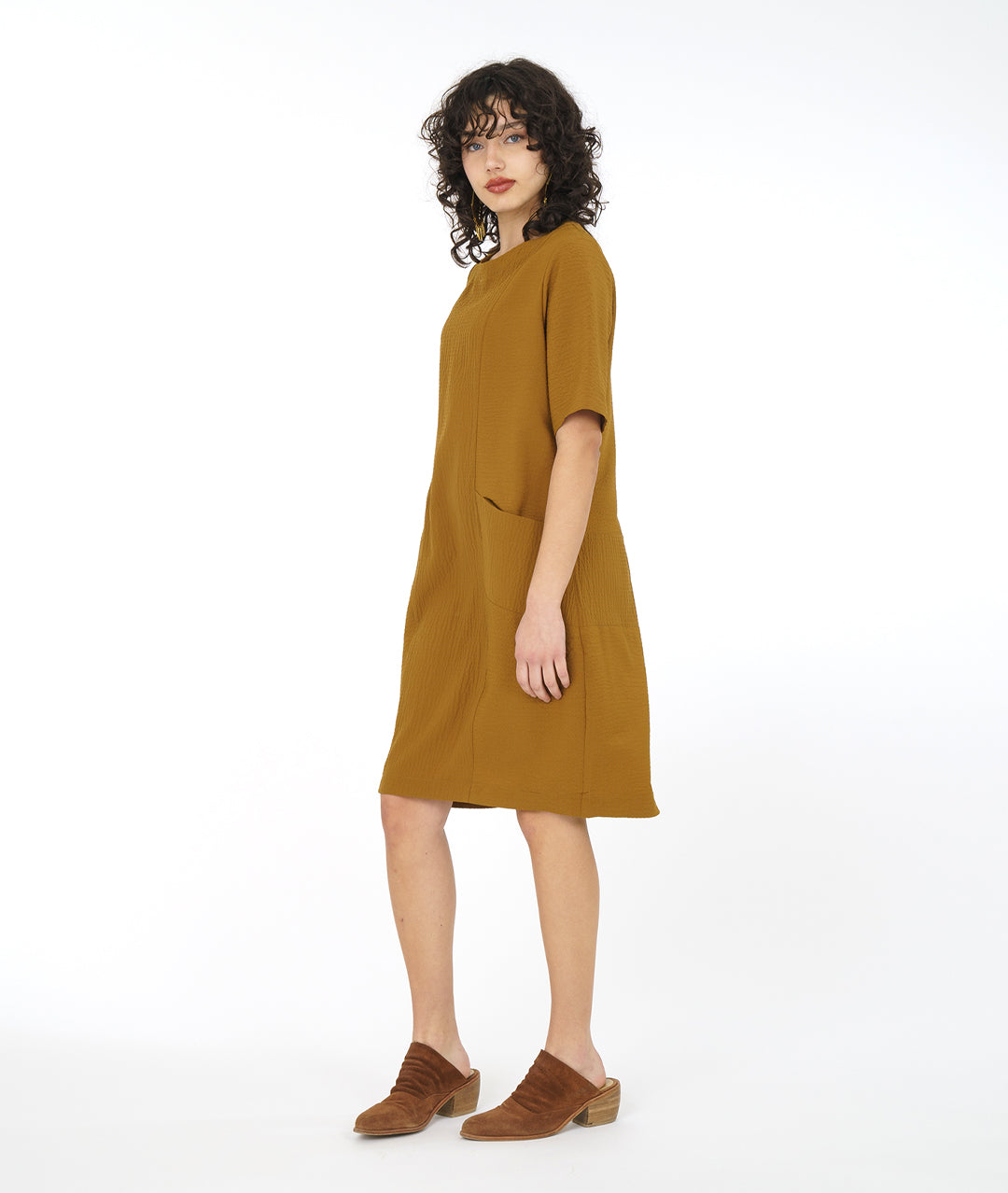 model in a dijon yellow shift dress with princess seams and angled hip pockets