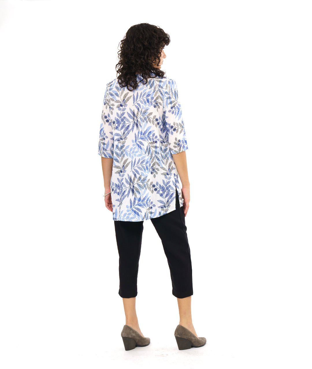 model in a black crop pant worn with a white pullover tunic with a blue and black leaf print. tunic has 3/4 sleeves and a split neckline with shell buttons