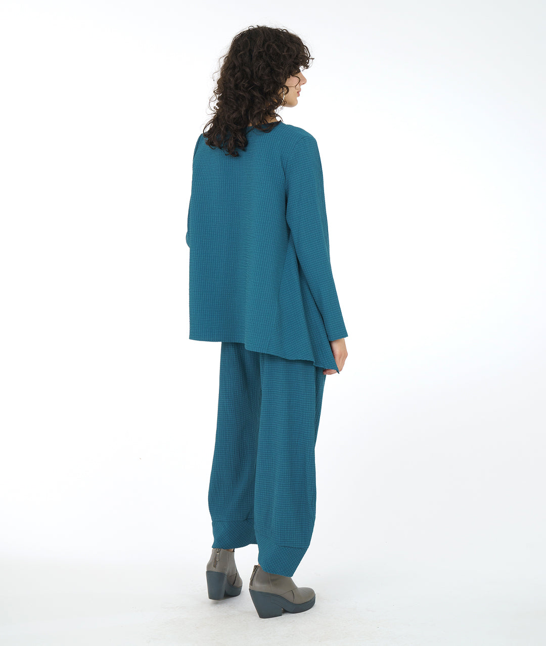 model in a teal flowy top with a matching textured pant with pockets, an elastic waistband, and a tapered cuff at the bottom hem