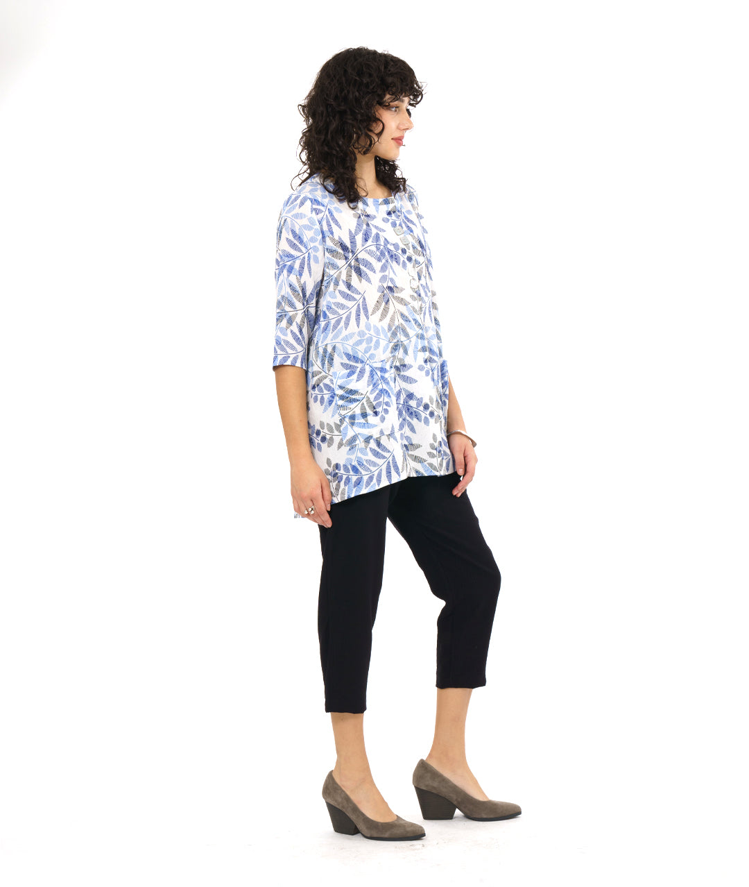 model in a black crop pant worn with a white pullover tunic with a blue and black leaf print. tunic has 3/4 sleeves and a split neckline with shell buttons