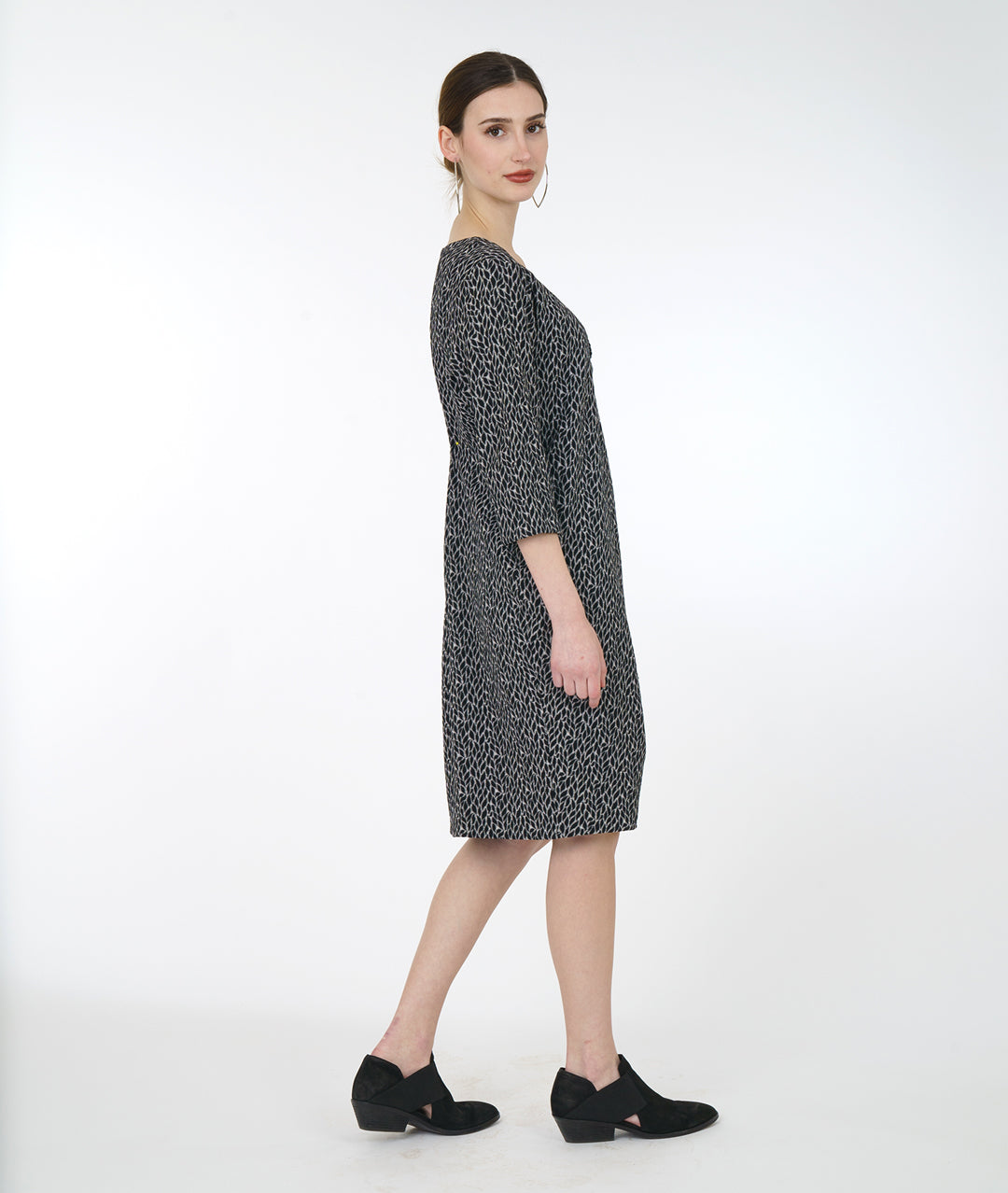model in a black and grey leaf shift dress with a flounce down the front