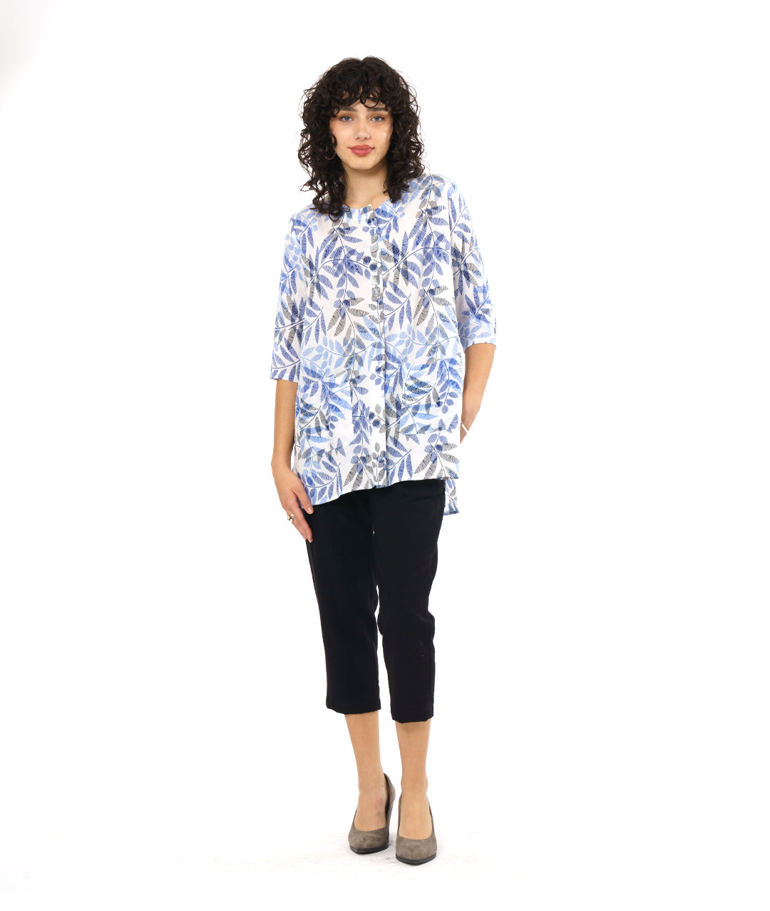 model in a black crop pant worn with a white pullover tunic with a blue and black leaf print. tunic has 3/4 sleeves and a split neckline with shell buttons