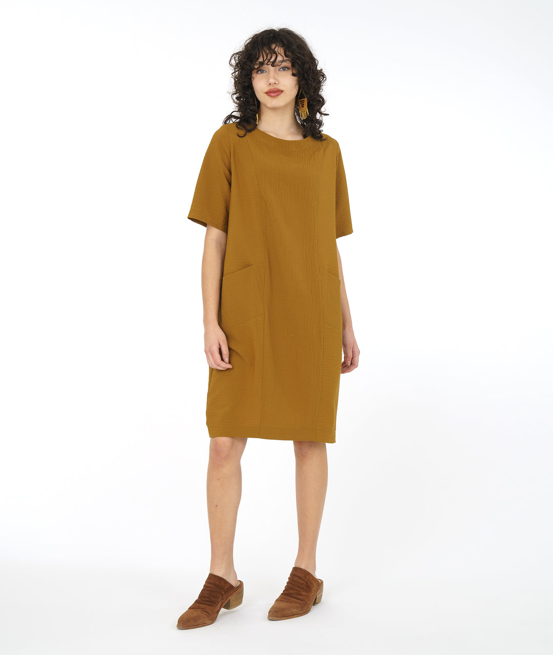 model in a dijon yellow shift dress with princess seams and angled hip pockets