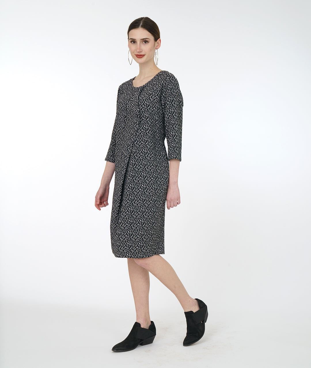 model in a black and grey leaf shift dress with a flounce down the front