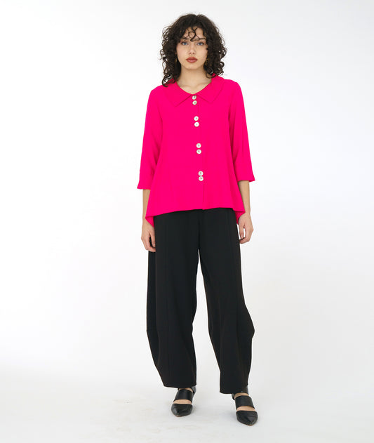 model in a wide leg black pant with a hot pink button down jacket with 3/4 sleeves and double sets of buttons