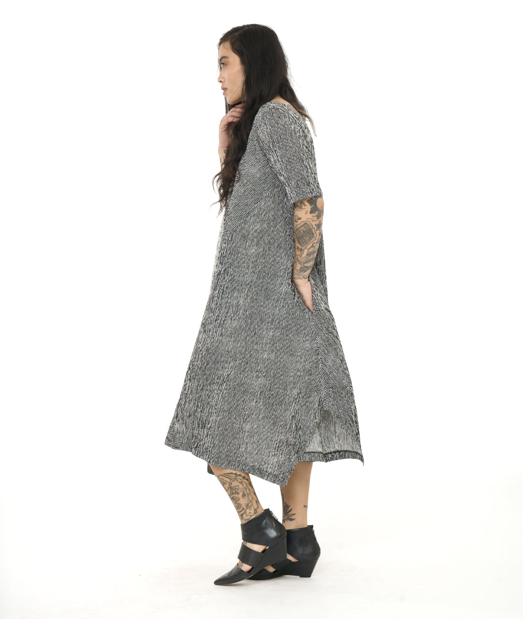 model in a black and white striped dress with contrasting panels and tucks on the sides