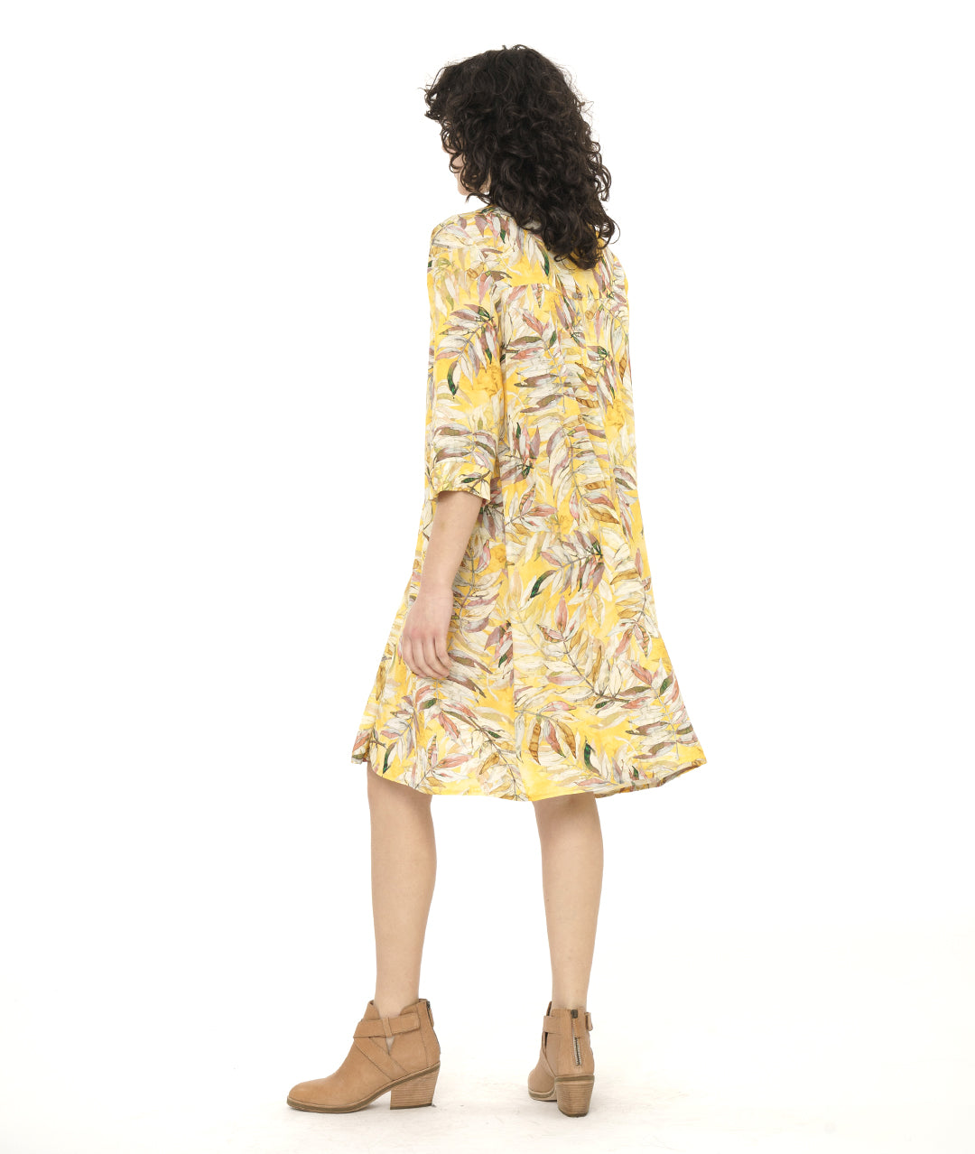 model in a yellow leaf print shirt dress with 3/4 sleeves and side seam pockets