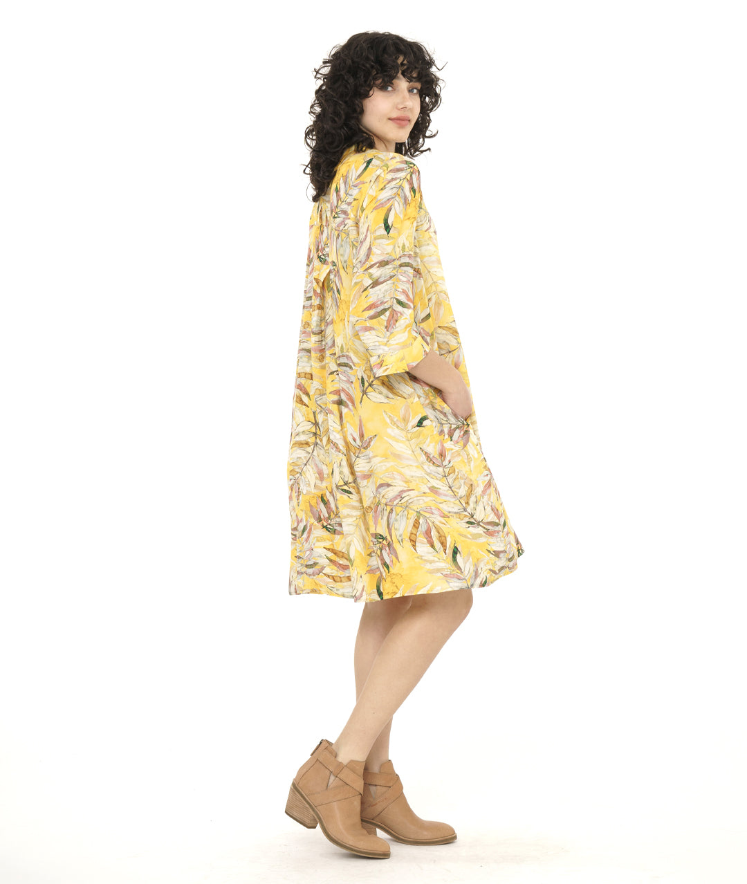 model in a yellow leaf print shirt dress with 3/4 sleeves and side seam pockets