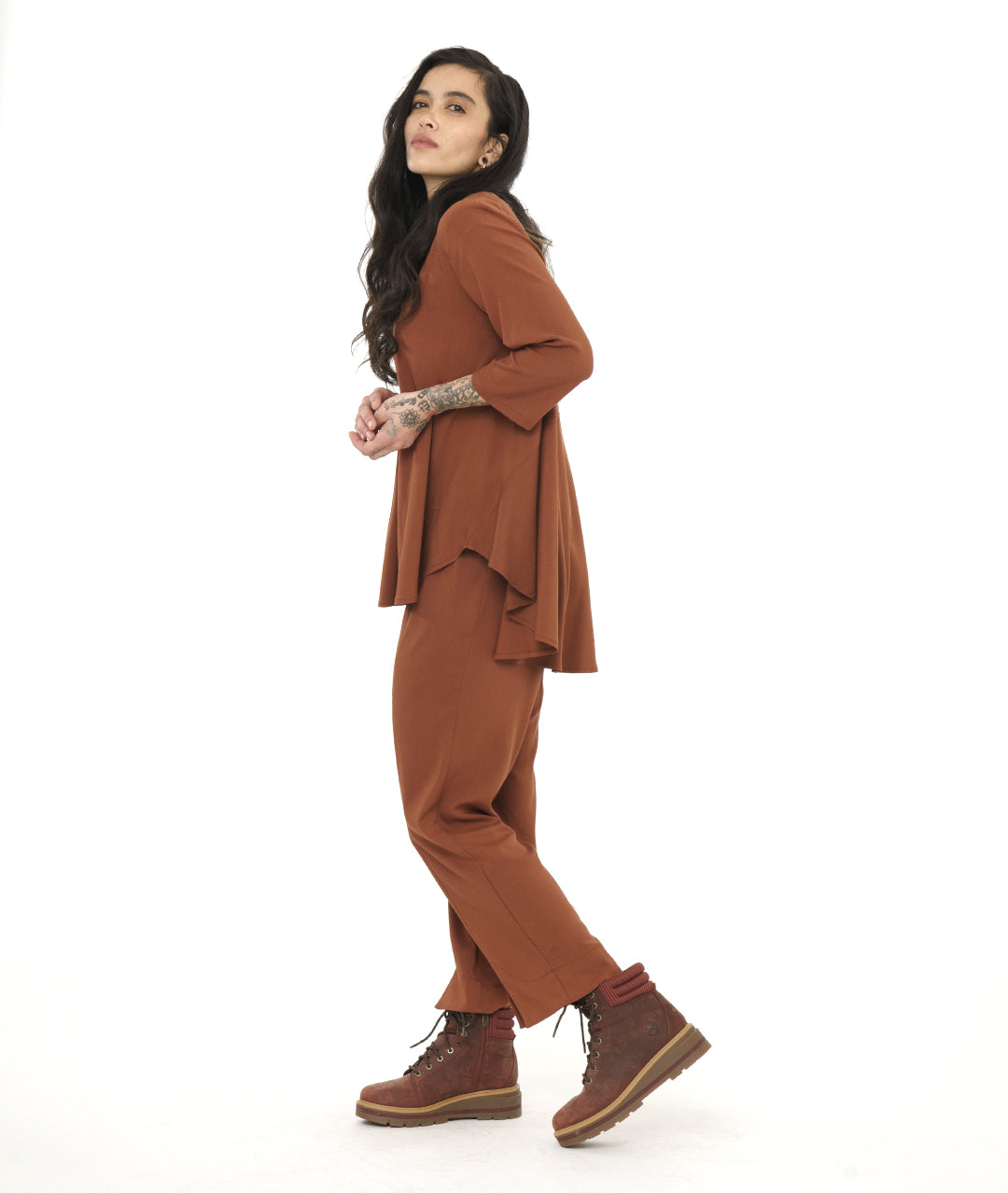 model in a rust color pullover top with a matching straight leg pant with a split at the center front hem