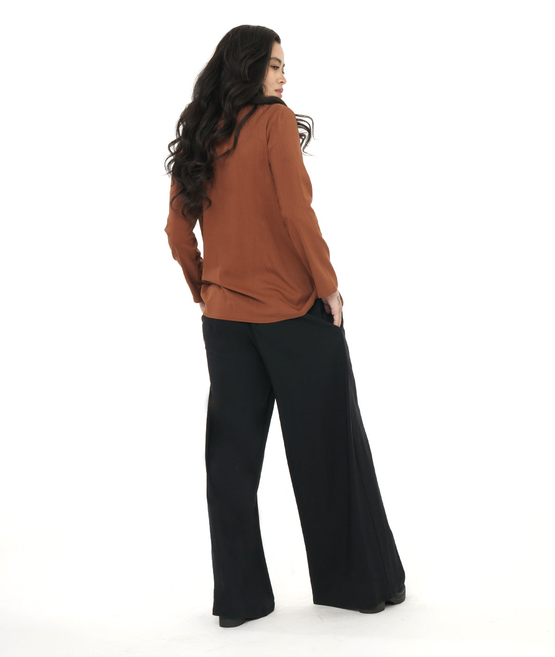model in a wide leg black pant, worn with a rust color button down blouse