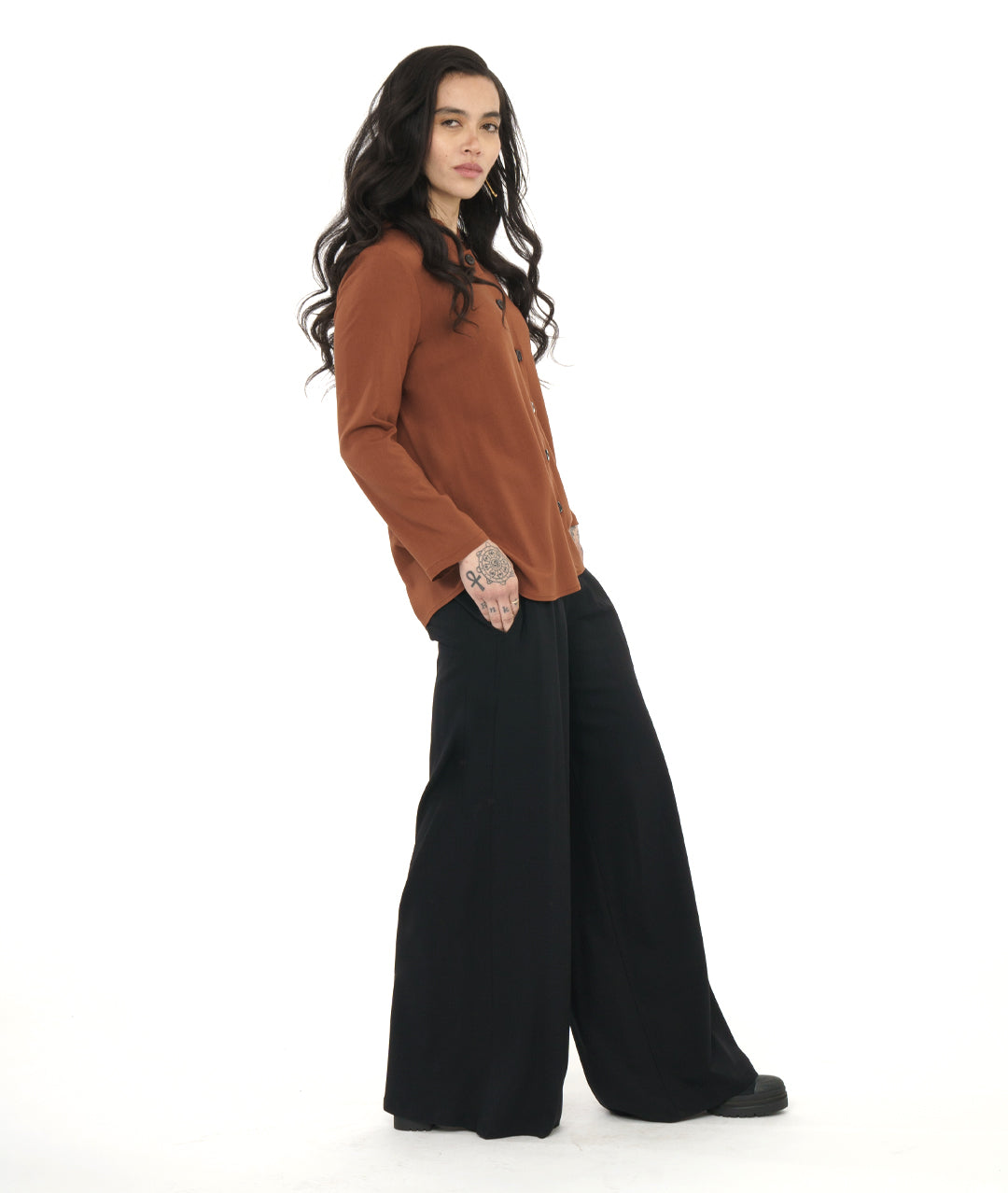 model in a wide leg black pant, worn with a rust color button down blouse