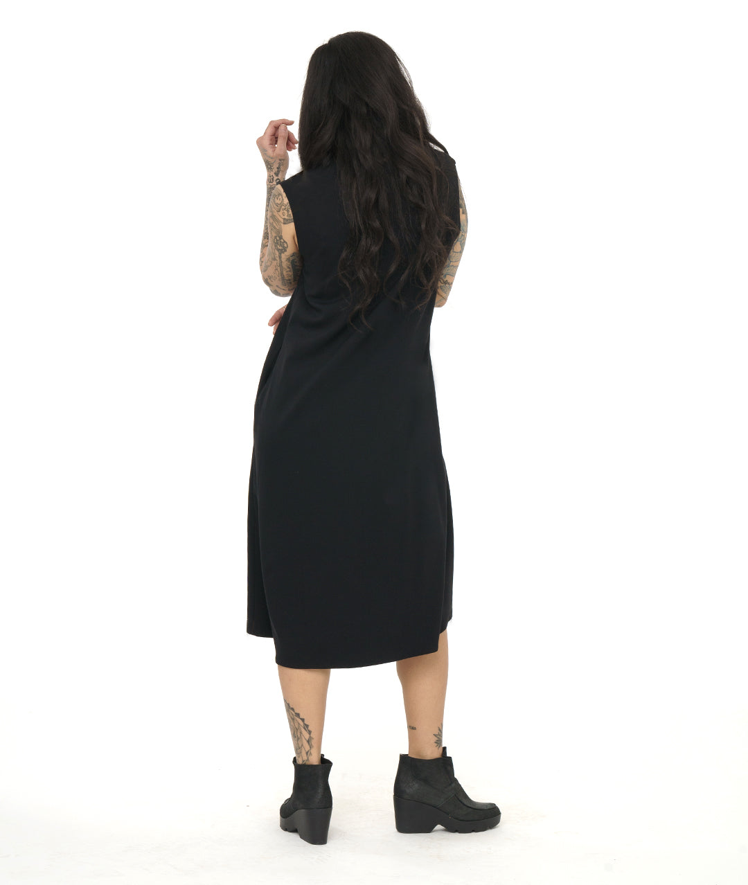 model in a black sleeveless dress with a v-neck and a center front seam