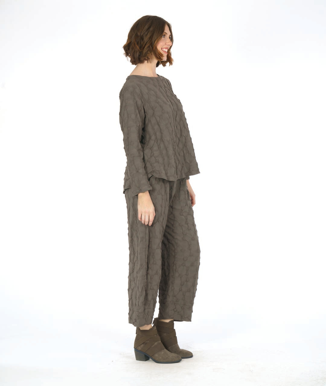 model in a wide leg green pant with a tapered ankle and a puckered dot texture, worn with a matching pullover top