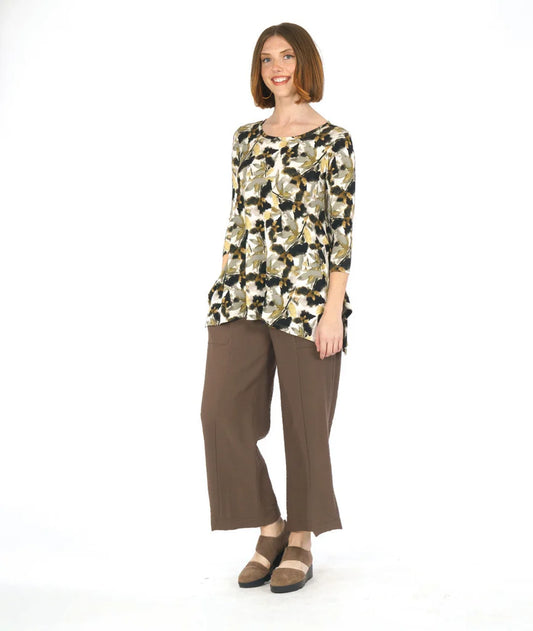 Woman wearing a floral top and brown pants on a white background