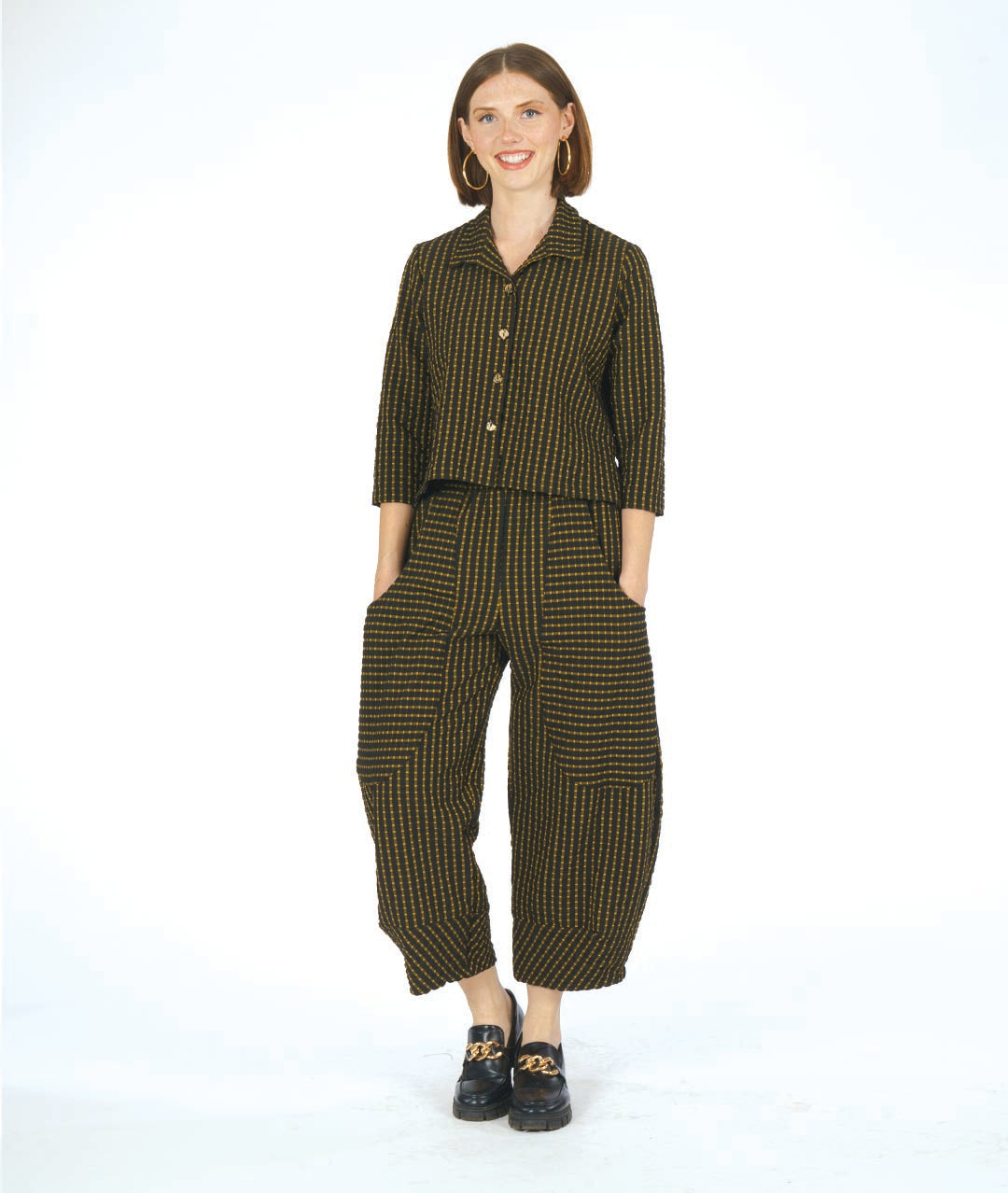 model in a black and yellow check print blouse with a matching wide leg pant with an oversized pocket and tapered ankle