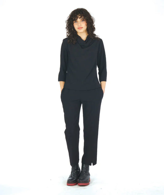 model wearing black 3/4 sleeve cowl neck top with black slim pants with slit at the ankle