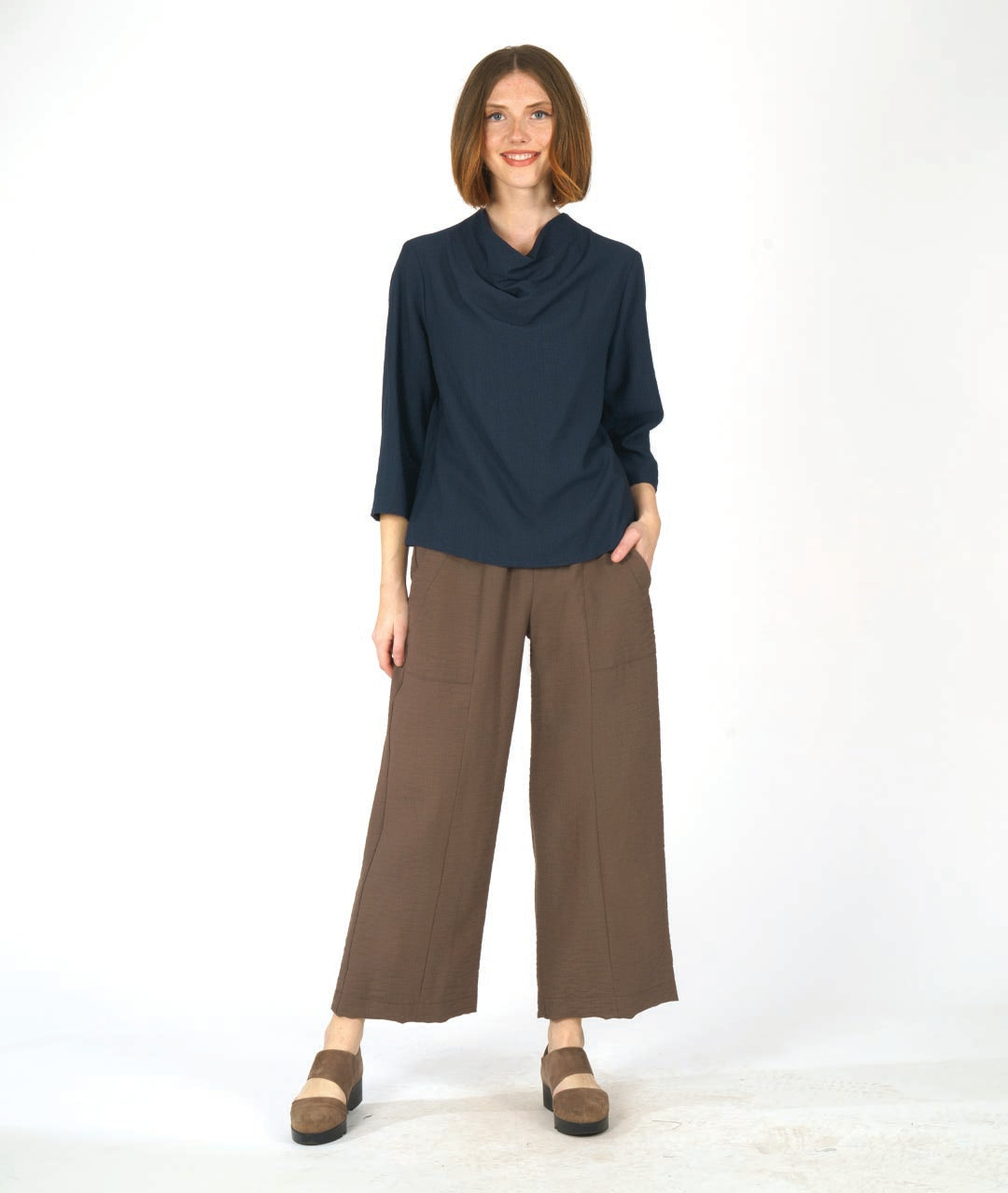 navy pullover top with 3/4 sleeves and a cowl neck, worn with a wide leg brown pant