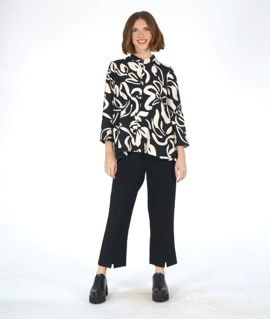 model in a straight cut black pant with a black and ivory floral print blouse with 3/4 sleeves, a mandarin style collar, and black and white buttons down the center front.