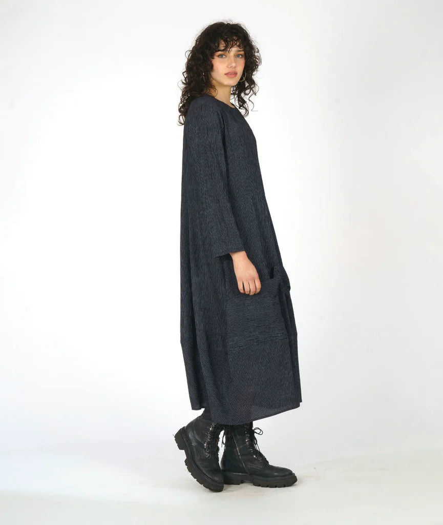 Woman wearing a long dark gray dress on a white background