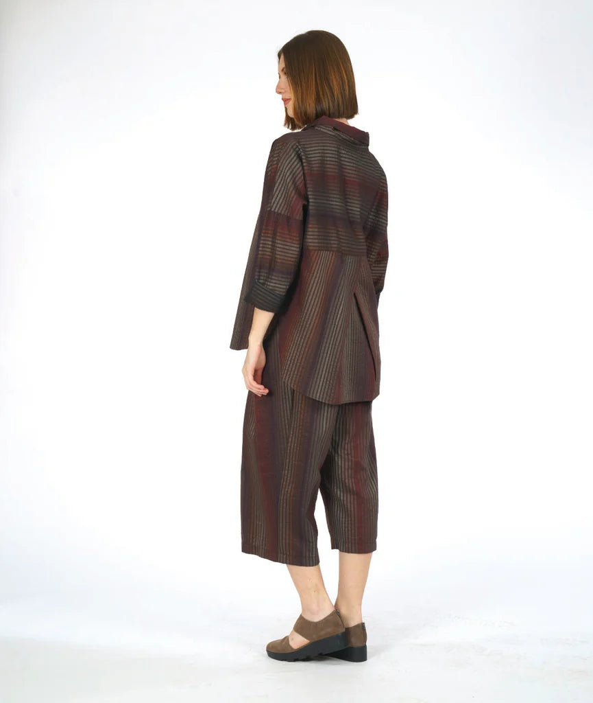 model showing back of striped top with pleated back on a white background