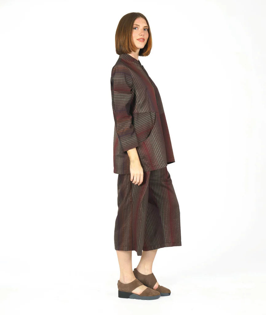 model wearing a brown striped button up long sleeve top and matching pants on a white background
