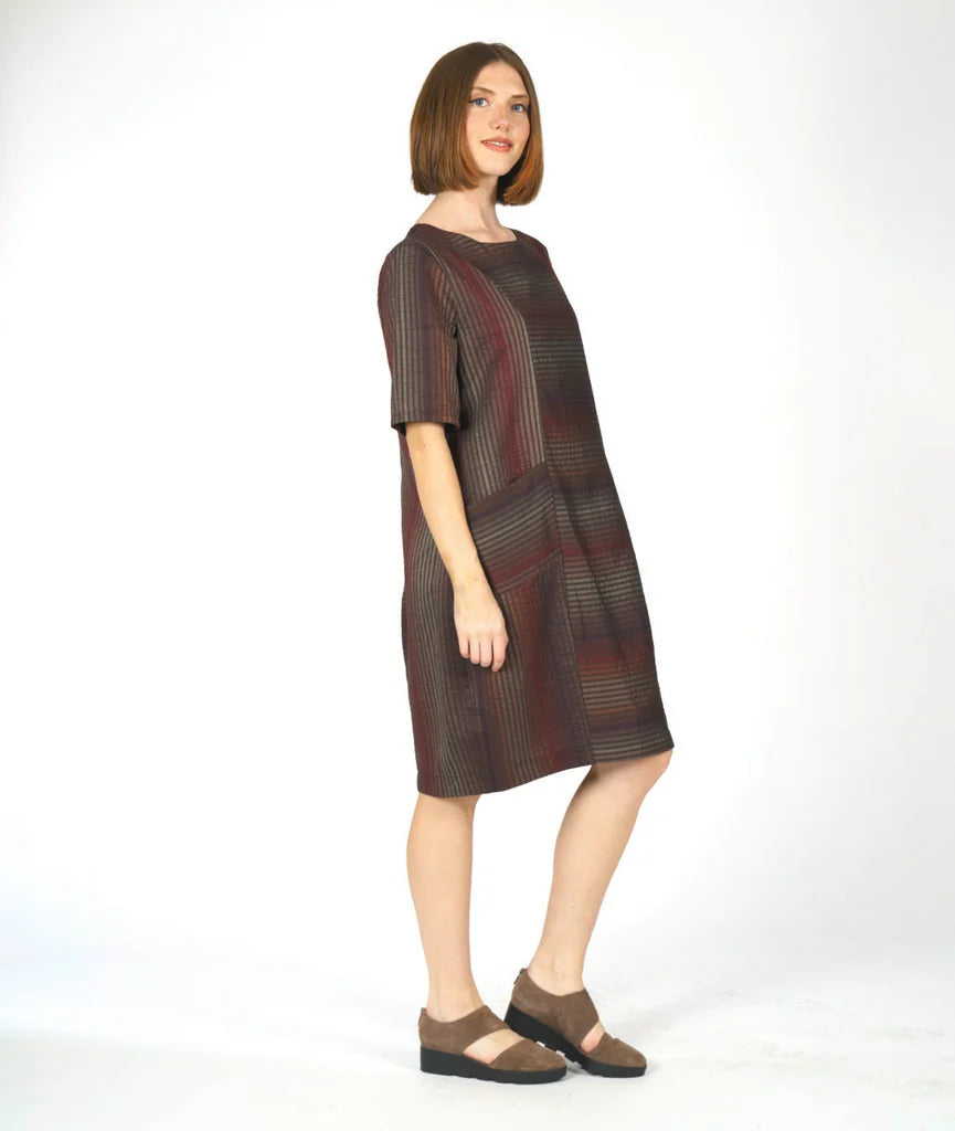 model wearing a striped half sleeve dress with two front pockets on a white background