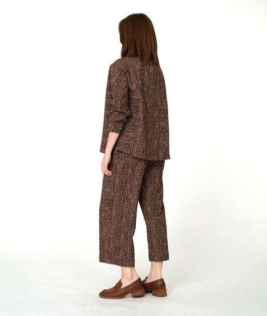 Woman wearing a brown textured outfit on a white background
