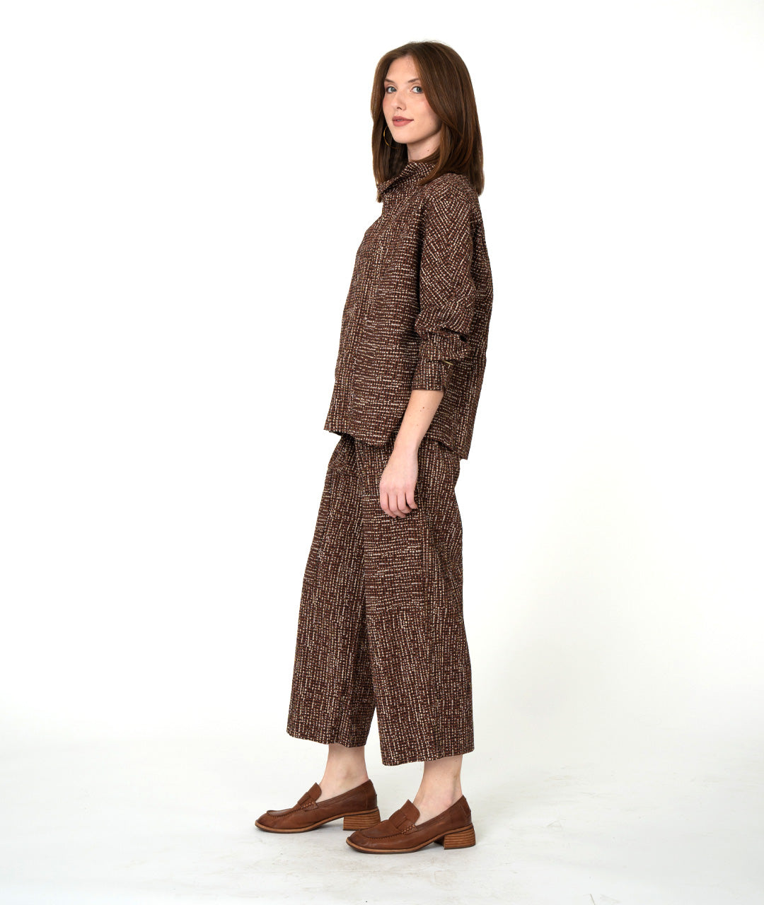 Woman wearing a brown textured outfit on a white background