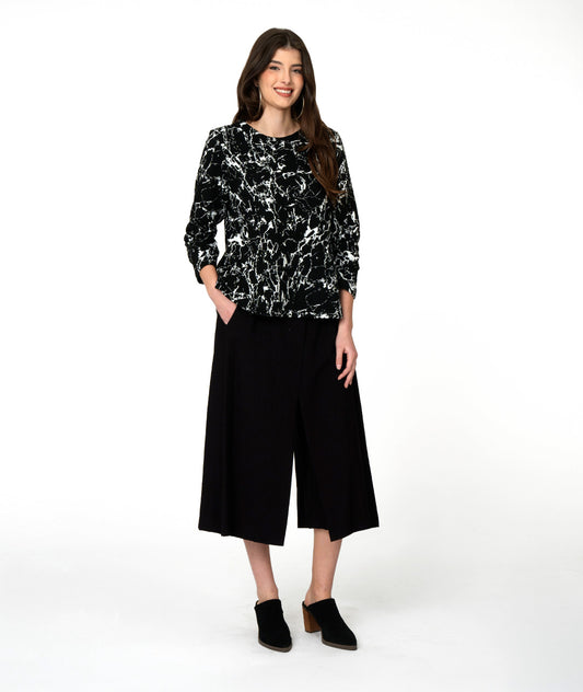 model in a wide leg black crop pant, worn with a black and white marble print long sleeve pullover top