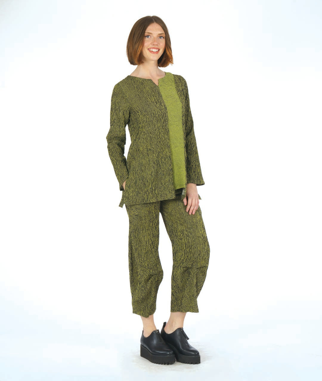 model in a black and green striped pant with a matching top with a contrasting panel. pant has a tulip shape