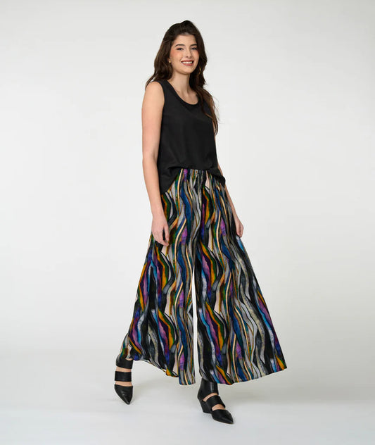 Model wearing black tank top with 'watercolor' pattern pants on white background.